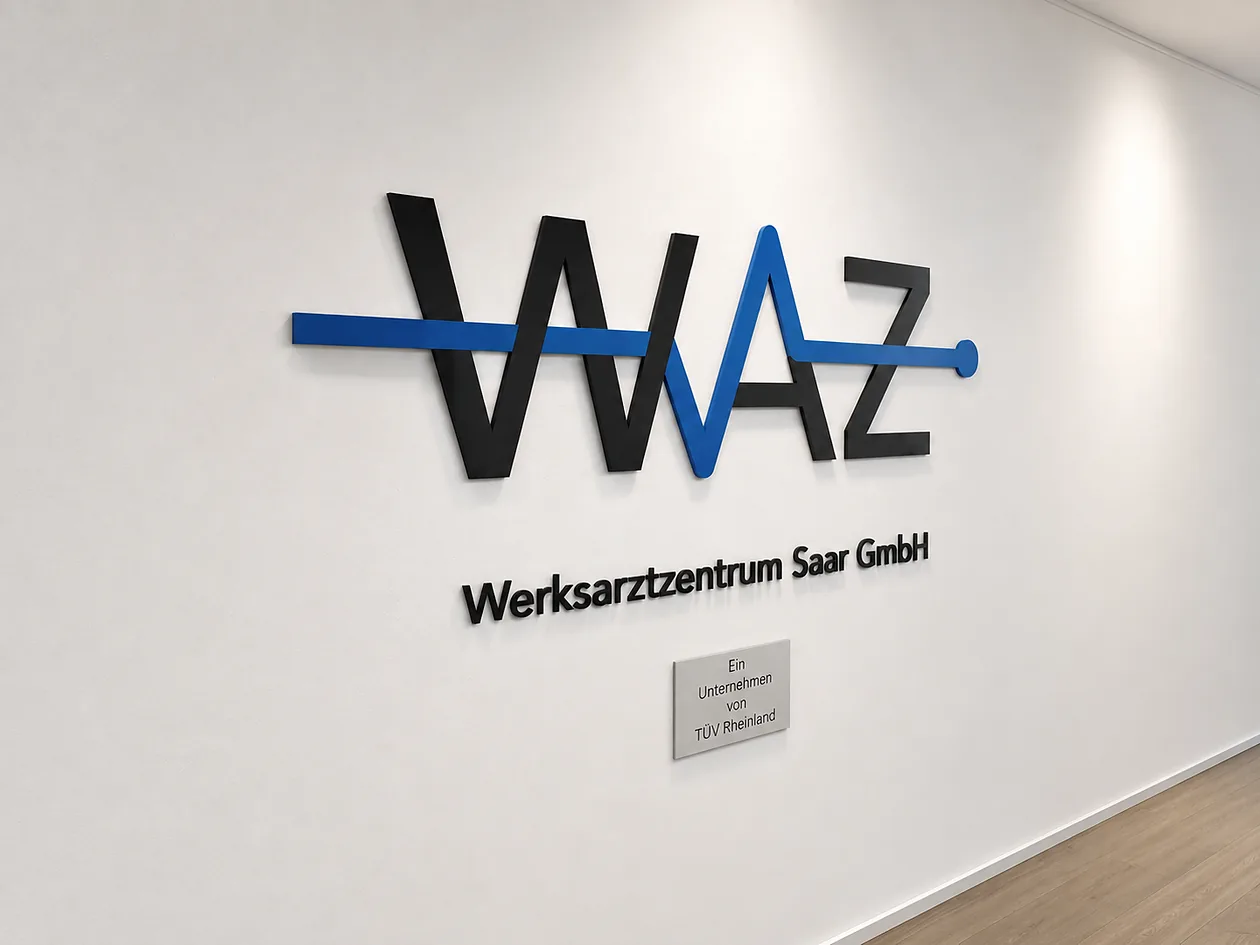 WAZ Werksarztzentrum Saar – Firmenlogo an der Bürowand mit dem Schild „Ein Unternehmen von TÜV Rheinland“